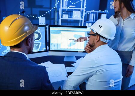 Engineers working in office at night Stock Photo