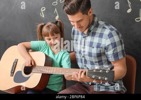 Teacher giving music lessons at school Stock Photo