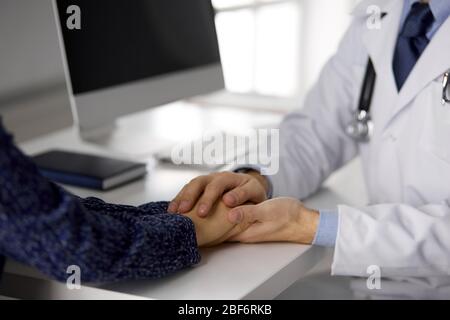 Friendly red-beard doctor reassuring his female patient, close-up. Medical ethics and trust concept, medicine theme Stock Photo