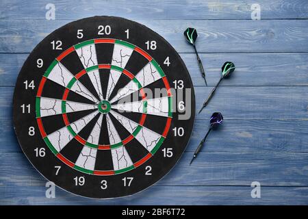 Dartboard with darts on wooden background Stock Photo