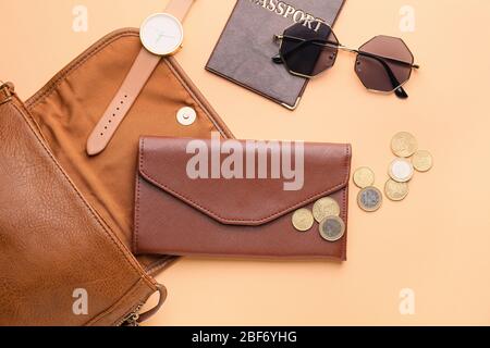 Purse with wallet, money, passport and accessories on color background Stock Photo
