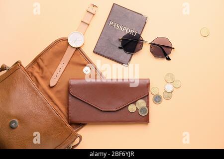 Purse with wallet, money, passport and accessories on color background Stock Photo