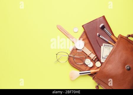 Purse with wallet, money and accessories on color background Stock Photo