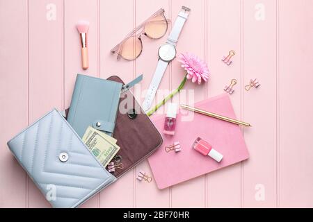 Purse with wallet, money, stationery and accessories on white wooden background Stock Photo