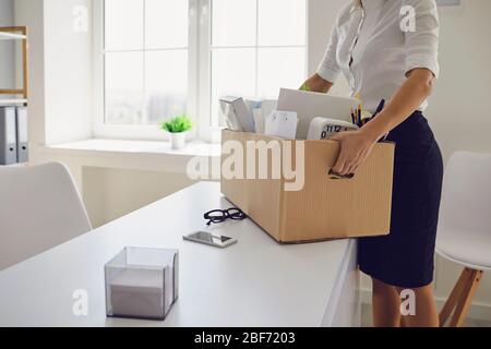 Unemployment Dismissed businesswoman upset with a cardboard box leaves the workplace from the office of the company. Stock Photo