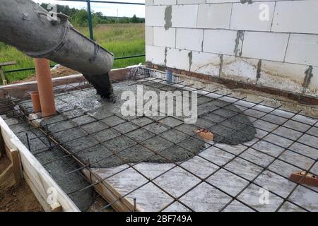 Pouring concrete after placing steel reinforcement to make a screed, the photo shows sewer pipes. 2019 Stock Photo