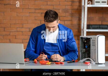 Electronic technician repairing computer in service center Stock Photo