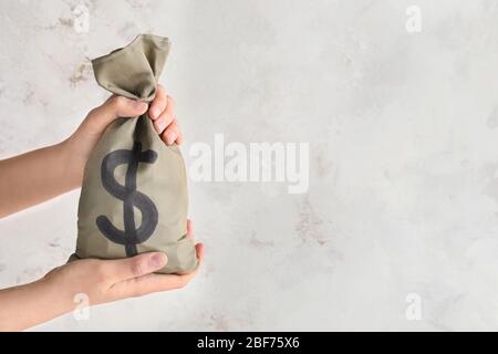 Female hands holding bag with money on white background Stock Photo