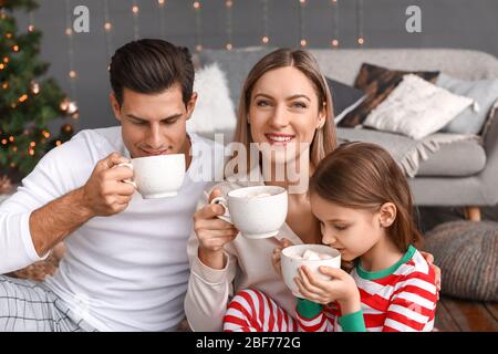 Happy family drinking hot chocolate on Christmas eve at home Stock Photo