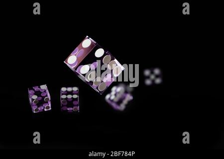 Purple Casino dices over black background Shallow depth of field Stock Photo