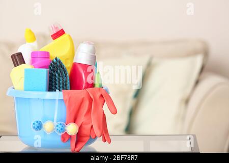 Set of cleaning supplies on table in room Stock Photo