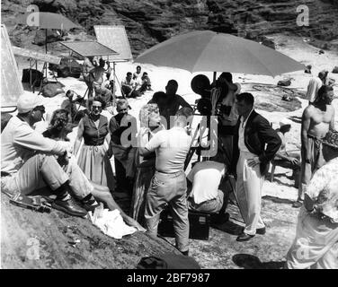 DEBORAH KERR with Make-Up Artists and BURT LANCASTER with Movie Crew on set location candid at Halona Cove , O'ahu Hawaii filming the famous beach love scene for FROM HERE TO ETERNITY 1953 director FRED ZINNEMANN novel James Jones screenplay Daniel Taradash Columbia Pictures Stock Photo