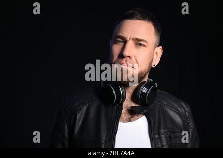 Handsome man with headphones on dark background Stock Photo