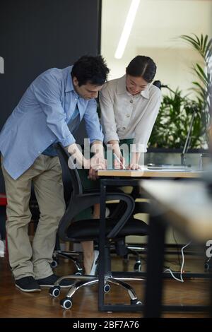Two busy colleagues working at the table with documents at office Stock Photo