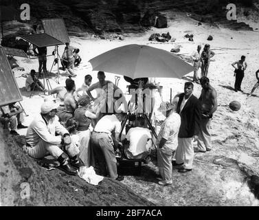 DEBORAH KERR with Make-Up Artists and BURT LANCASTER on set location candid at Halona Cove , O'ahu Hawaii filming the famous beach love scene for FROM HERE TO ETERNITY 1953 director FRED ZINNEMANN novel James Jones screenplay Daniel Taradash Columbia Pictures Stock Photo