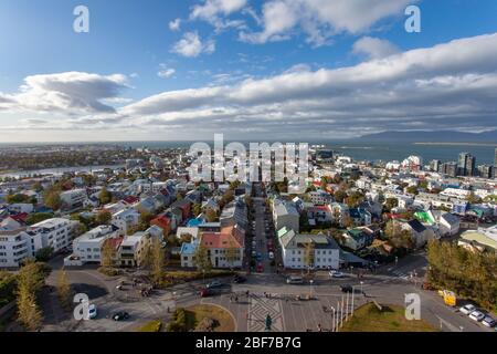 A view from the Hallgrímskirkja church in Reykjavík, Iceland, showing colorful houses, a blue sky with white and grey clouds, and the harbor Stock Photo