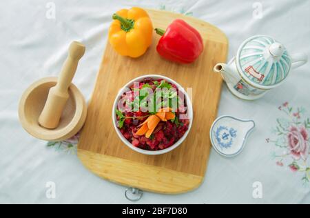 Slices of boiled beets in a plate. Healthy food, diet salad with beets . Fresh colorful salad: beets, carrots, cabbage served on a wooden board Stock Photo