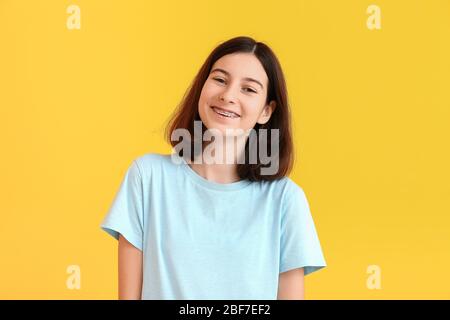 Teenage girl with dental braces on color background Stock Photo