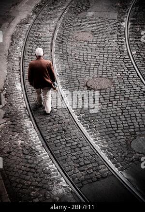 Elderly man walking down the street in Lisbon Stock Photo