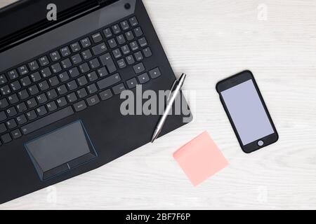home office concept with blank sticky adhesive note and blank phone screen Stock Photo