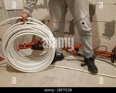 Underfloor heating is mounted on a pipeline installer, heating system and underfloor heating.2020 Stock Photo
