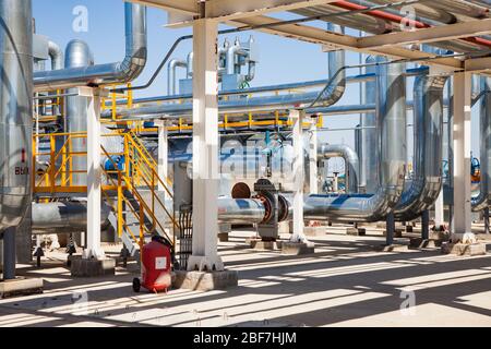 Petrochemical plant. Oil refinery plant. Abstract view of tubes and valve armature and pipelines in sunny day. Stock Photo