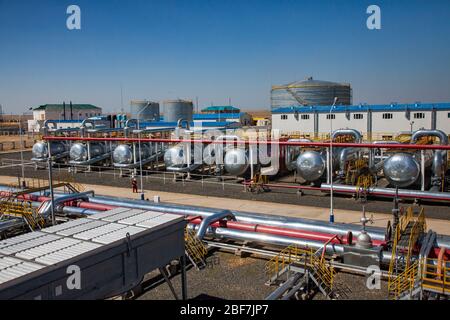 Petrochemical plant. Panorama of oil refinery plant in desert. Heat exchangers, oil storage tanks, pipelines and factory building. Stock Photo