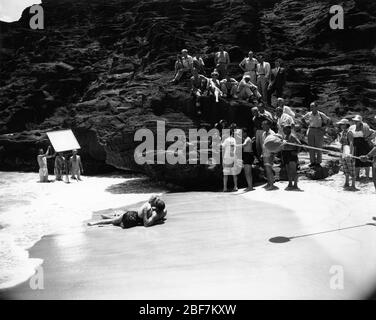 BURT LANCASTER and DEBORAH KERR with Movie Crew on set location candid at Halona Cove , O'ahu Hawaii filming the famous beach love scene for FROM HERE TO ETERNITY 1953 director FRED ZINNEMANN novel James Jones screenplay Daniel Taradash Columbia Pictures Stock Photo