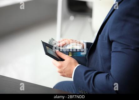 Businessman counting money in office Stock Photo