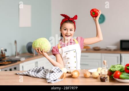 Little housewife cooking in kitchen Stock Photo