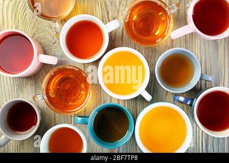 Cups with different types of hot tea on table Stock Photo