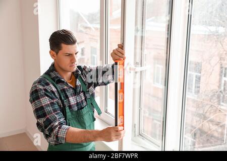 Male worker installing window in flat Stock Photo