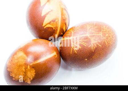 Traditional way of easter egg dyeing. Negative of small plant leaves on egg shell dyed with red onion, Hungary. Stock Photo