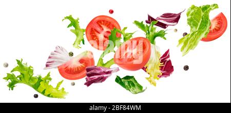 Falling salad of leaves with rucola, lettuce, radicchio, romano green frize and tomatoes Stock Photo