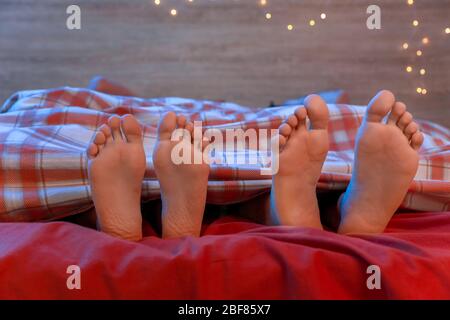 Feet of young couple sleeping in bed at night Stock Photo
