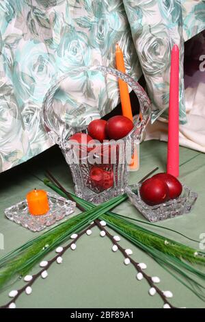 red painted eggs with flowers and candles for celebration Easter holiday Stock Photo