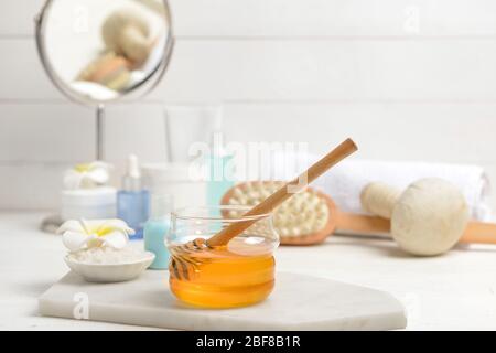 Jar with honey and spa items on table Stock Photo