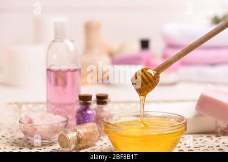 Jar with sweet honey and spa items on table Stock Photo