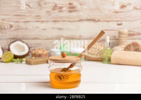 Jar with sweet honey and spa items on table Stock Photo