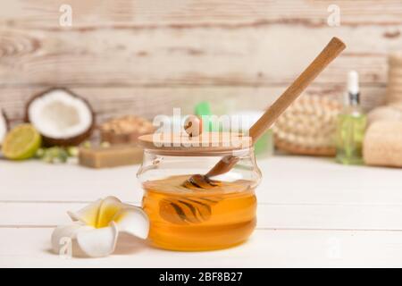 Jar with sweet honey and spa items on table Stock Photo