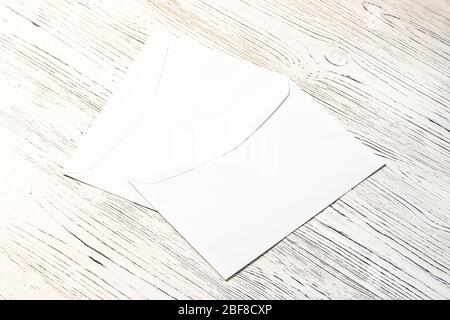 Two white postal envelopes on a wooden table. Abstract background for design. Art stylized baner or mock up with copy space for a text. Stock Photo