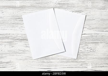 Two white postal envelopes on a wooden table. Abstract background for design. Art stylized baner or mock up with copy space for a text. Stock Photo