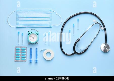Set of medical supplies with alarm clock on color background Stock Photo