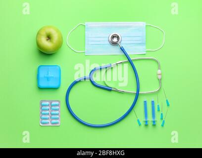 Set of medical supplies with apple on color background Stock Photo