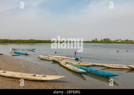 JOAL-FADIOUTH, SENEGAL - NOVEMBER15, 2019: Fishers and small long boats. Fadiauth Island. Senegal. West Africa. Stock Photo