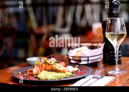 Chicken with specially crafted avocado sauce accompanied by white wine Stock Photo