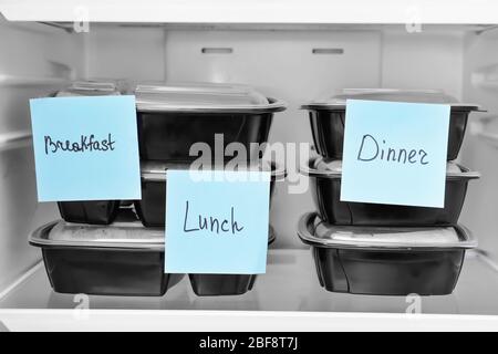 Containers with healthy food on shelf in fridge Stock Photo