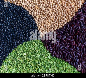 Multicolored mixed of raw dry legumes composition: green peas, kidney bean, black Mexico bean, chickpea. Close-up. Flat lay Stock Photo