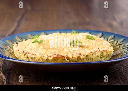 Turkish berek with cheese on a blue dish. Turkish national cuisine. A dish consisting of dough, herbs, potatoes, eggs and strewn with cheese. Stock Photo
