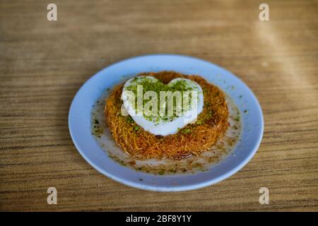 Traditional Turkish dessert known as Kunefe. Specially crafted heart-shaped ice cream on the Turkish dessert Kunefe Stock Photo